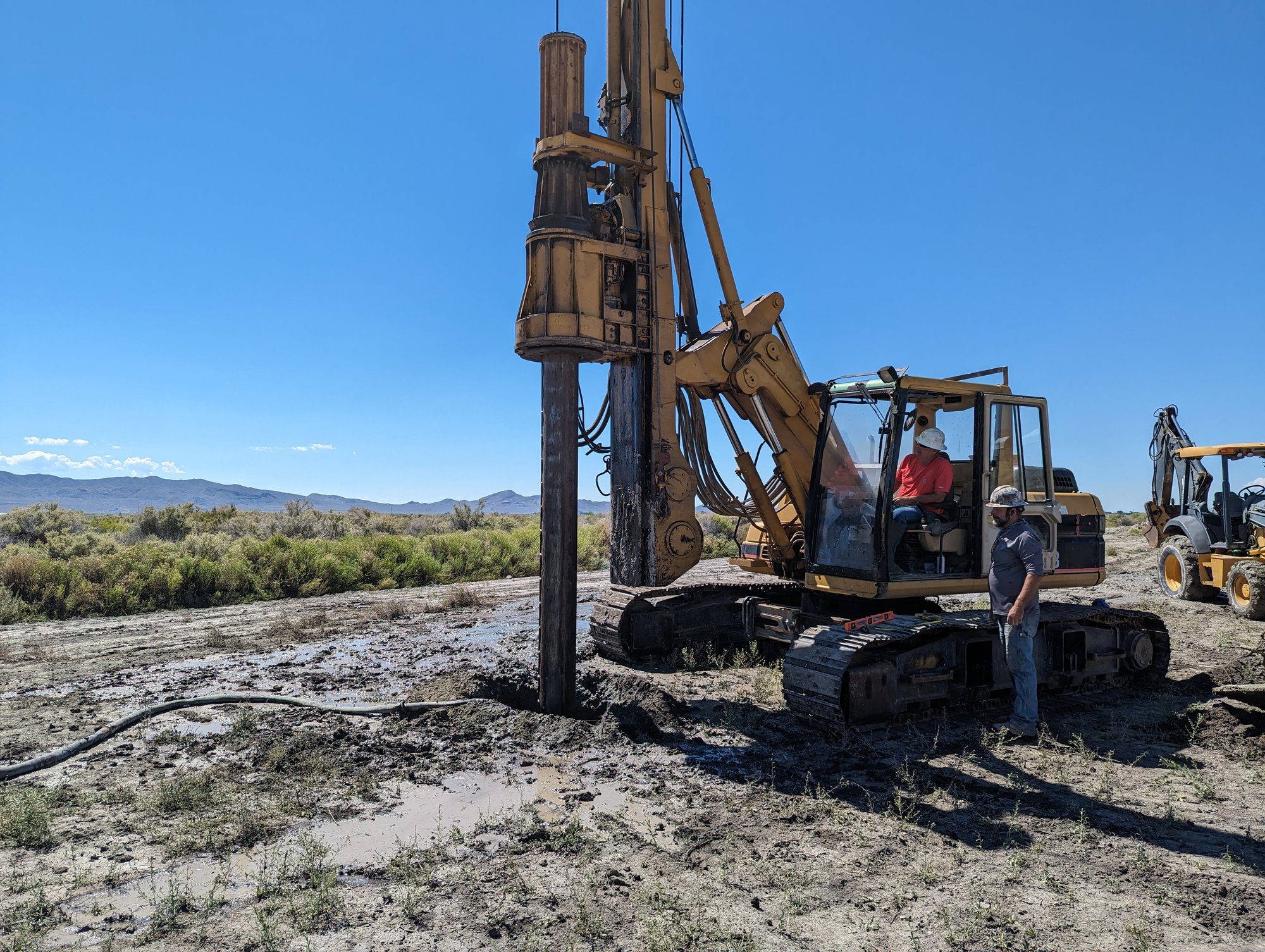 A drilling crew works on irrigation pump repairs
